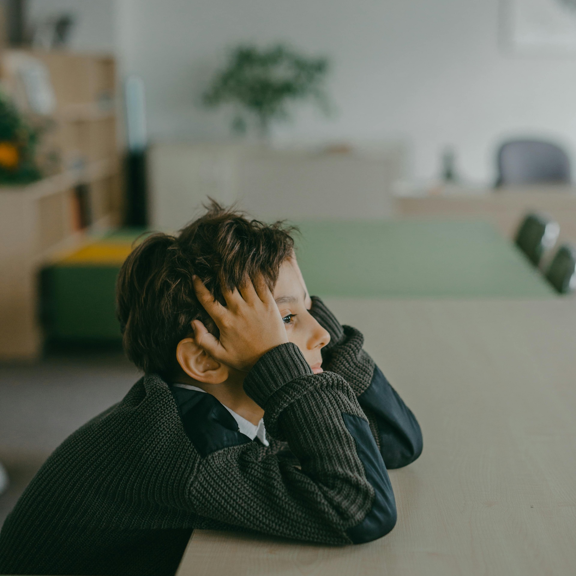 Child looking thoughtful and overwhelmed at a desk